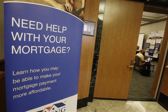 In this March 11, 2010 file photo, home owners wait inside a meeting room before their names are called so they can meet with housing counselors and representatives from major lenders gathered to help homeowners facing foreclosure.